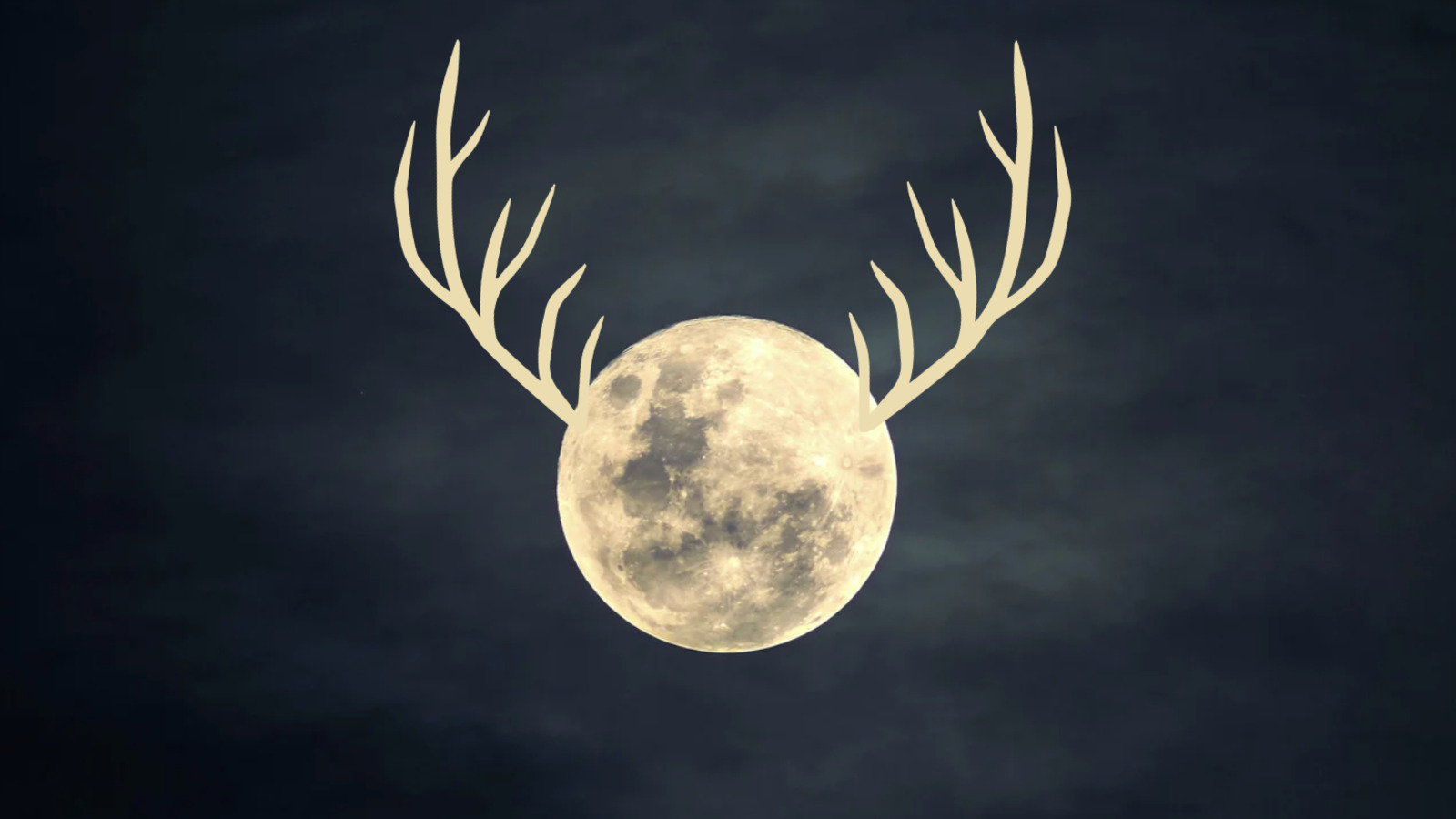 A full moon is pictured against a dark sky, with antler-like horns protruding from either side of its fully-lit disk.